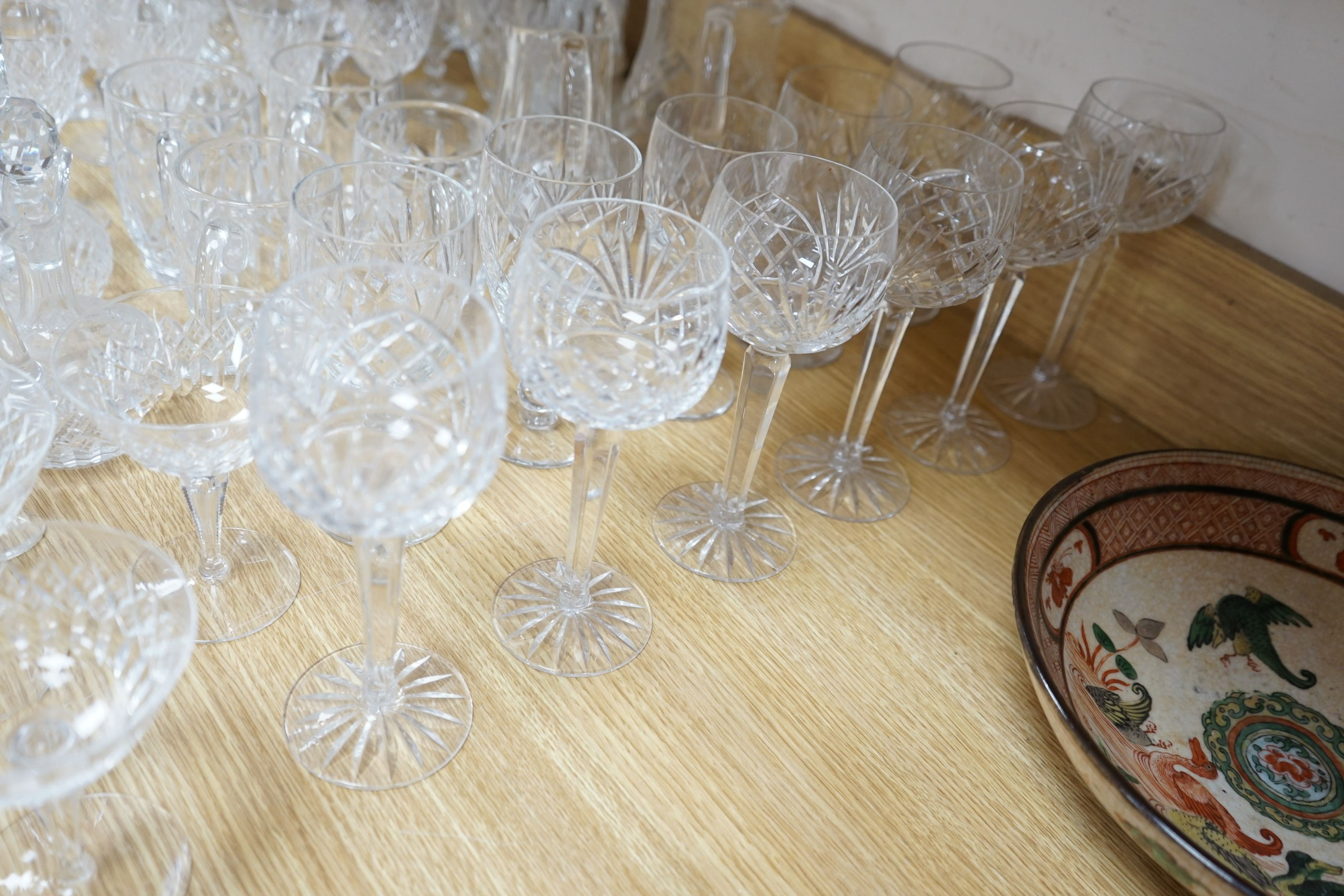 A suite of cut drinking glassware and a pair of porcelain figural lamp stems
